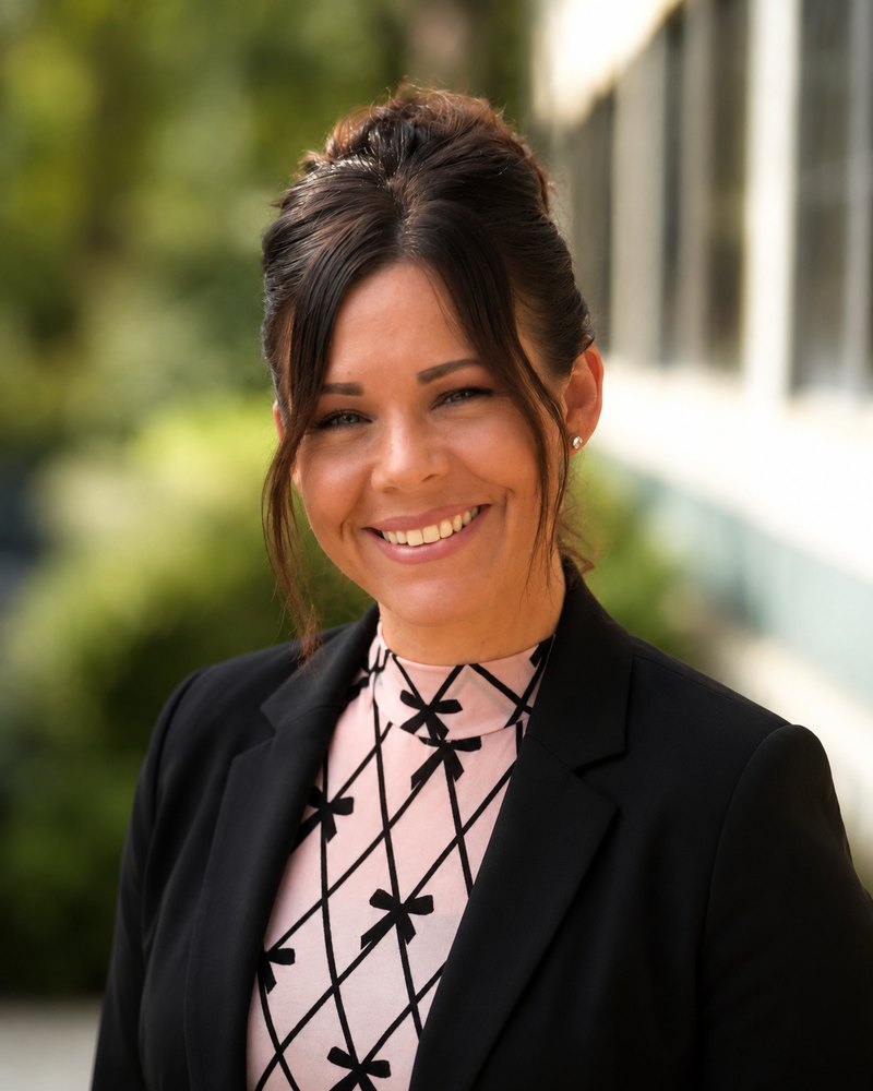 Roxanne Stegall, smiling, in a black blazer outdoors